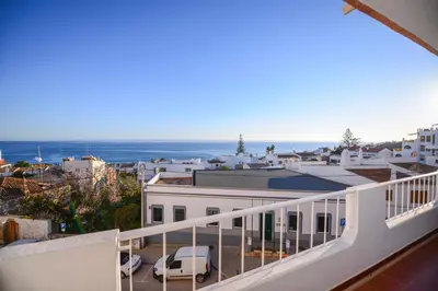 a balcony with a view of a city and the ocean at SEAFRONT LUZ APARTMENT in Luz
