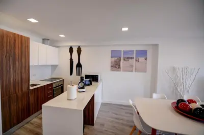 a kitchen with a table and a white counter top at SEAFRONT LUZ APARTMENT in Luz