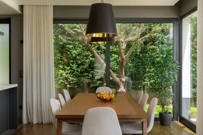 a dining room with a wooden table and white chairs at OurMadeira - Bella Vita in Calheta