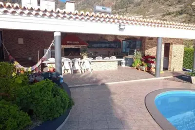 a house with a patio and a swimming pool at Arcos Grands Suites with enormous and private pool. in Arco da Calheta