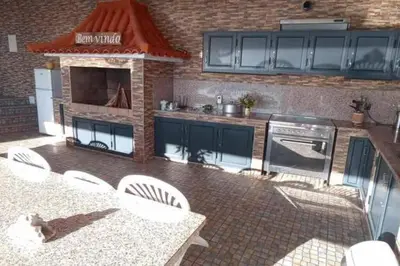 a kitchen with blue cabinets and a table and chairs at Arcos Grands Suites with enormous and private pool. in Arco da Calheta