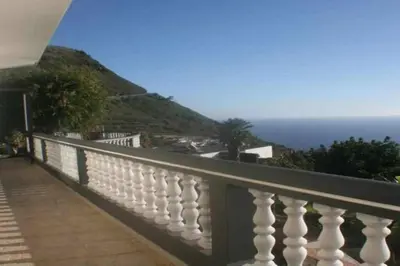 a white balcony with a view of the ocean at Arcos Grands Suites with enormous and private pool. in Arco da Calheta