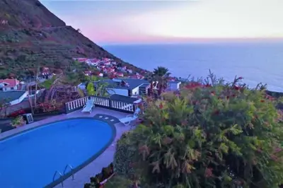 an aerial view of a swimming pool next to the ocean at Arcos Grands Suites with enormous and private pool. in Arco da Calheta