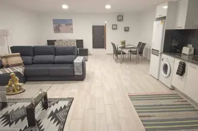a living room with a couch and a table and a kitchen at Arcos Grands Suites with enormous and private pool. in Arco da Calheta