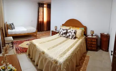 a bedroom with a large bed and two night stands at Arcos Grands Suites with enormous and private pool. in Arco da Calheta