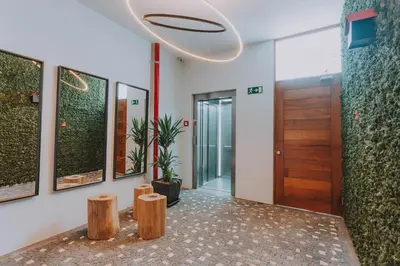 a hallway with wooden stools and a door at FLH Casa Branca Madeira in Funchal