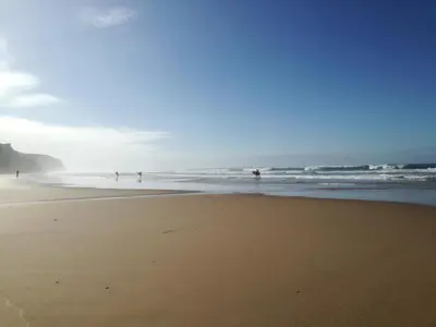 a beach with people playing in the ocean at chabouco 2 (Mien) in Aljezur