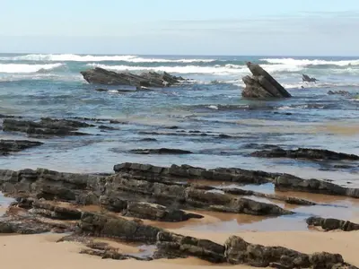 a view of the beach with rocks in the water at chabouco 2 (Mien) in Aljezur