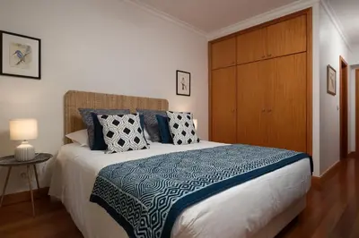 a bedroom with a large bed with a wooden closet at Vista Monumental by LovelyStay in Funchal