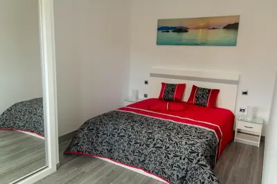 a bedroom with a bed with red pillows and a mirror at Amoreira House in Calheta