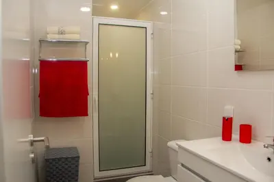 a bathroom with a toilet and a red towel at Amoreira House in Calheta