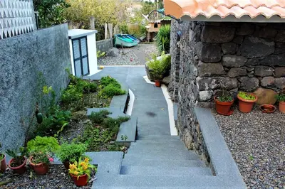 a garden with potted plants and a stone wall at Cottage Quinze & Apartment with Swimming pool in Ponta Delgada