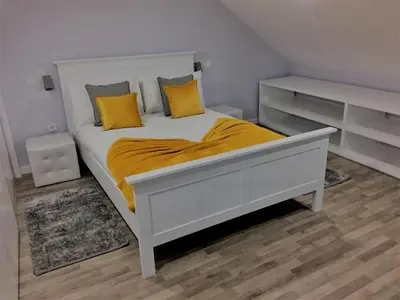 a white bed with yellow pillows in a bedroom at Cottage Quinze & Apartment with Swimming pool in Ponta Delgada