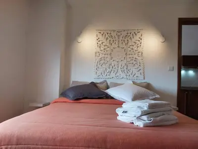 a bedroom with a red bed with towels on it at Tabua Village Madeira Suite 6 Adventure with Ocean View in Ribeira Brava