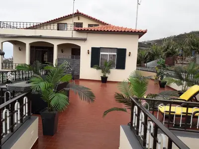 a house with a balcony with palm trees at Tabua Village Madeira Suite 6 Adventure with Ocean View in Ribeira Brava