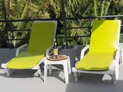 two green chairs and a table with a bottle of champagne at Tabua Village Madeira Suite 6 Adventure with Ocean View in Ribeira Brava