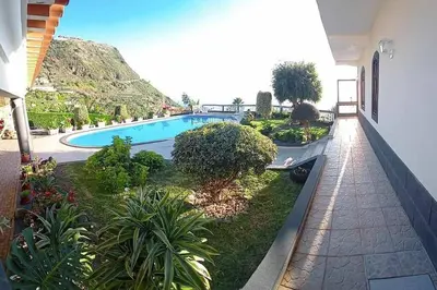 a view of a swimming pool from the balcony of a house at Arcos Grand Suites with pool in Calheta
