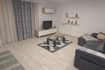 a living room with a couch and a tv at Arcos Grand Suites with pool in Calheta