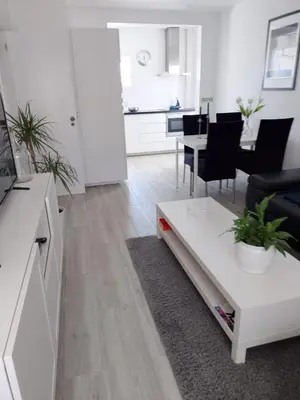a white living room with a couch and a table at Casa Florival in Burgau