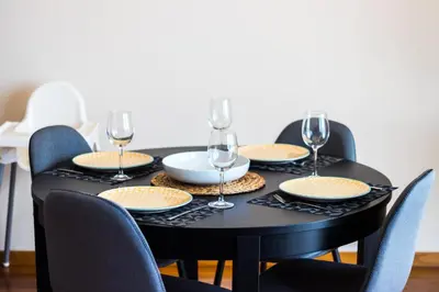 a black table with chairs and wine glasses on it at Acacia Apartment by Atlântica in Funchal