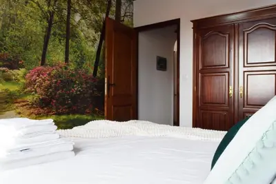 a bedroom with a bed and a wooden door at Casa da Piedade, a Home in Madeira in Ponta do Sol