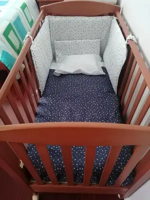 a wooden crib with a blue and white mattress at Lido Funchal Apartment balcony sea view in Funchal