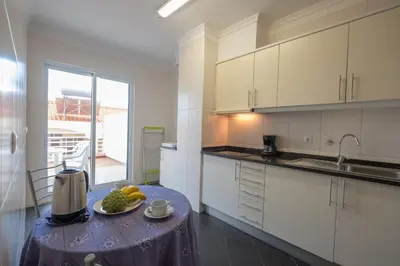 a kitchen with a table with a plate of fruit on it at Apartments Madeira in Caniço