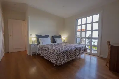 a bedroom with a bed and a large window at Apartments Madeira in Caniço