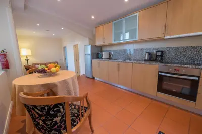 a kitchen with a table with a bowl of fruit on it at Apartments Madeira in Caniço