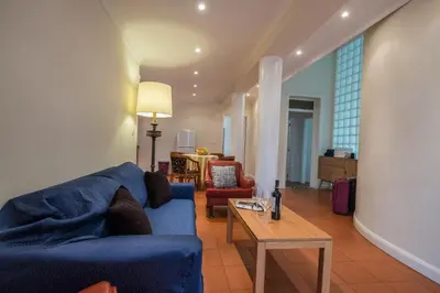 a living room with a blue couch and a table at Apartments Madeira in Caniço
