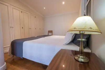 a bedroom with a bed and a lamp on a table at Apartments Madeira in Caniço