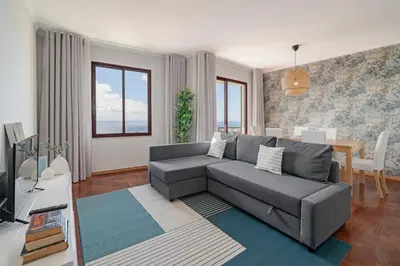 a living room with a gray couch and a table at Garajau IV by An Island Apart in Caniço