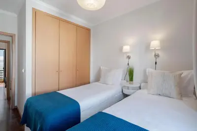 a bedroom with two beds and a cabinet at Garajau IV by An Island Apart in Caniço