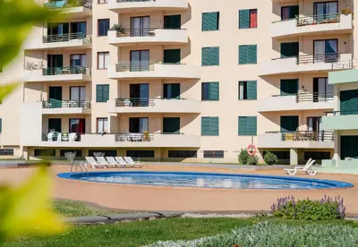 an apartment building with a swimming pool in front of it at Garajau IV by An Island Apart in Caniço