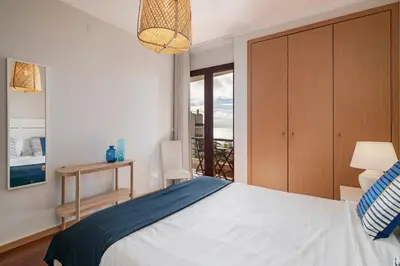 a bedroom with a large bed and a balcony at Garajau IV by An Island Apart in Caniço
