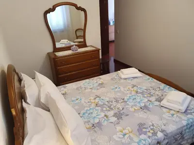a bedroom with a bed with a dresser and a mirror at SAO PEDRO APARTMENT in Santa Cruz