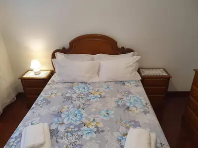 a bedroom with a bed with a blue floral bedspread at SAO PEDRO APARTMENT in Santa Cruz