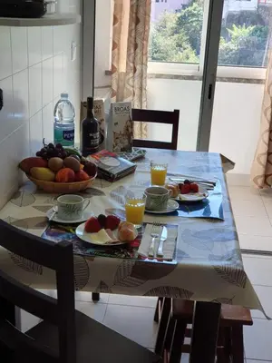 a table with a bowl of fruit and glasses of orange juice at SAO PEDRO APARTMENT in Santa Cruz