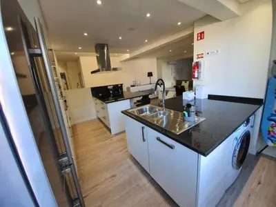 a kitchen with a sink and a refrigerator at Sunrise Glances & Free Parking in Funchal