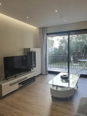 a living room with a flat screen tv and a table at Sunrise Glances & Free Parking in Funchal