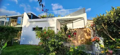 a white house with some flowers and plants at Casas Floeca in Ponta do Sol