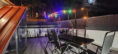 a table and chairs on a balcony at night at Casas Floeca in Ponta do Sol