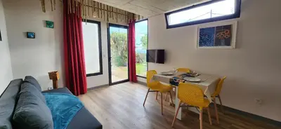 a living room with a couch and a table and chairs at Casas Floeca in Ponta do Sol