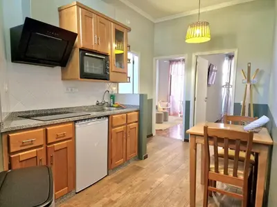 a kitchen with wooden cabinets and a counter top at ASPA Studios - Urban Conscious Living in Funchal