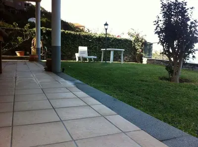 a patio with a chair and a table and grass at PDelgada 3-Bed House Sleeps 6 Parking & Sea View in Ponta Delgada