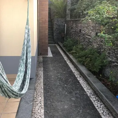 a walkway with a hammock hanging from a building at PDelgada 3-Bed House Sleeps 6 Parking & Sea View in Ponta Delgada