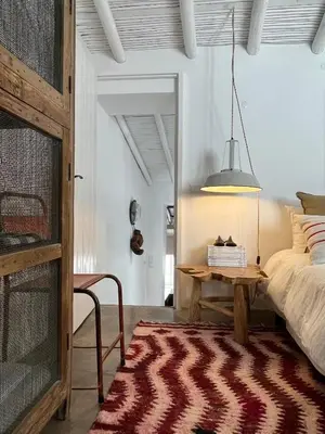 a bedroom with a bed and a table with a rug at Casa da Oliveira - Bordeira in Bordeira