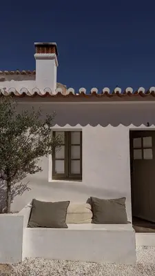 a white house with a couch in front of it at Casa da Oliveira - Bordeira in Bordeira