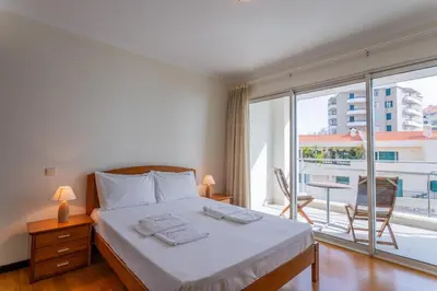 a bedroom with a bed and a large window at FLH Funchal Balcony Apartment with Sea View in Funchal