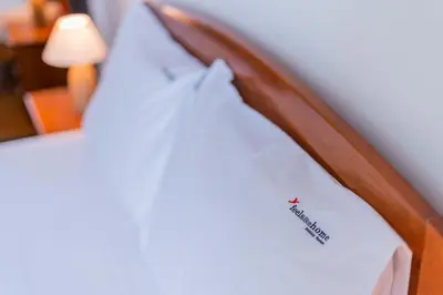 a wooden bed with a white shirt on it at FLH Funchal Balcony Apartment with Sea View in Funchal